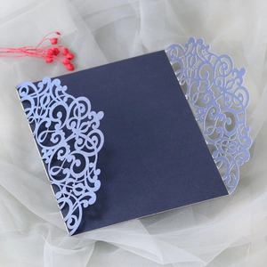 Detail of laser-cut wedding invitation with intricate floral patterns and glitter finish