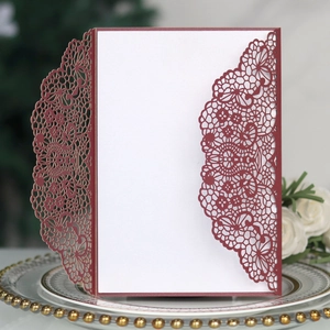 Détail du faire-part de mariage en dentelle bordeaux découpée au laser et carte blanche