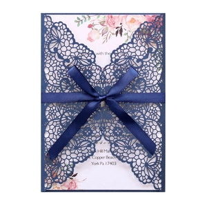 Détail de l'invitation de mariage bleue découpée au laser avec dentelle et ruban satin