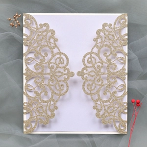 Detailed laser-cut gold glitter wedding invitation with elegant scrollwork pattern