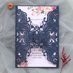 Detailed laser-cut vine patterns on dark blue card with elegant floral inner page