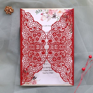 Detail of red laser cut lace wedding invitation with glitter finish and floral inner card