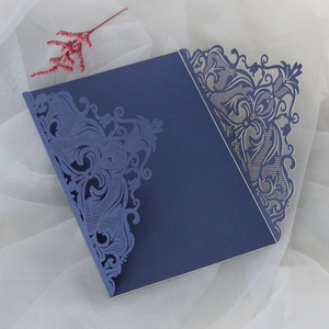 Macro detail of laser-cut navy blue pearlescent lace paper for wedding invitations