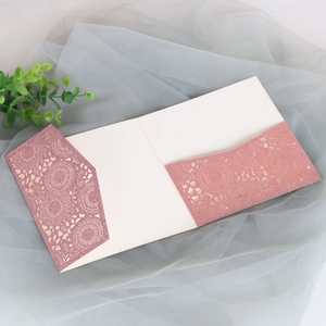 Détail de l'invitation découpée au laser en or rose pailleté avec une carte intérieure crème