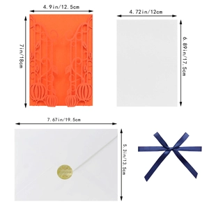 Detailed view of laser-cut pumpkin invitation set with envelopes and blue satin ribbon