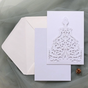 Detail of laser-cut bridal gown wedding invitation with inner card and white envelope