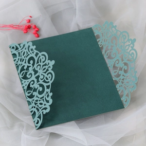 Detail of laser-cut green butterfly wedding invitation with elegant hollow patterns