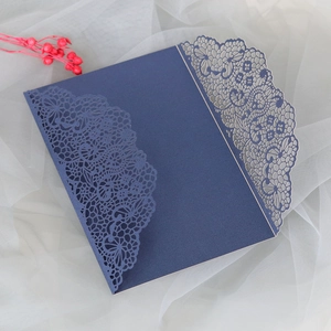 Détail de dentelle découpée au laser sur invitation de mariage bleu marine à motifs fleurs