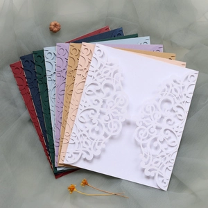 Laser-cut wedding invitations showing detailed European patterns in multiple pearlescent colors