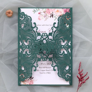 Macro detail of laser-cut butterfly lace invitation with soft floral inner card