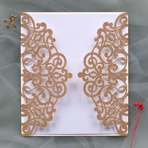 Macro view of champagne gold laser-cut wedding card with elegant floral hollow pattern