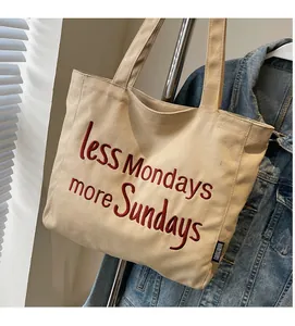 Detail of beige canvas tote with red embroidered text Less Mondays More Sundays
