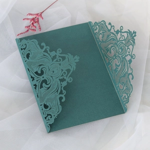 Macro view of dark green laser-cut wedding invitation with intricate floral lace patterns