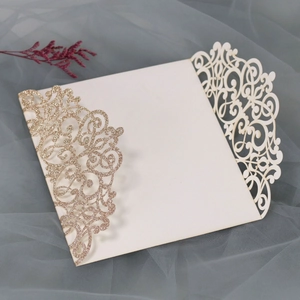 Detail of laser-cut lavender wedding invitation with gold glitter patterns and white card