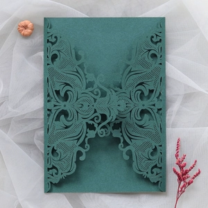 Detailed laser-cut dark green wedding invitation with intricate lace floral patterns