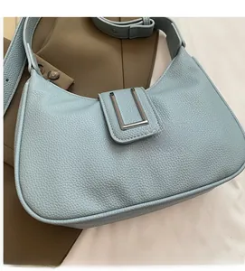 Détail du cuir à motif litchi bleu clair avec une grande boucle en métal en forme de U