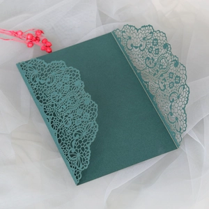 Vue détaillée de l'invitation de mariage vert foncé avec motif floral délicat découpé au laser