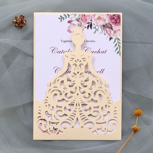 Close-up of laser-cut wedding invitation with bridal dress design and floral inner card