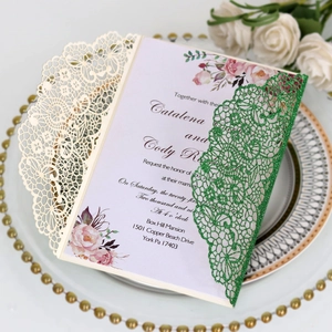Macro shot of laser-cut lace wedding invitation with glitter detail and floral inner card