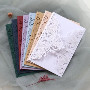 Detailed flat lay of laser-cut wedding invitation covers in eight assorted pearlescent colors