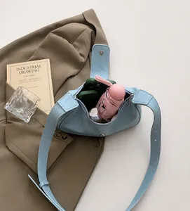 Vue détaillée du grand intérieur du sac hobo bleu clair avec accessoires du quotidien
