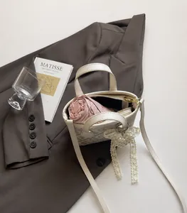 Detail showing the internal capacity of the white bucket bag with a small pink umbrella