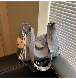 Detailansicht der hellblauen Hobo-Tasche mit Blumendruck, Bärenanhänger und Schnalle
