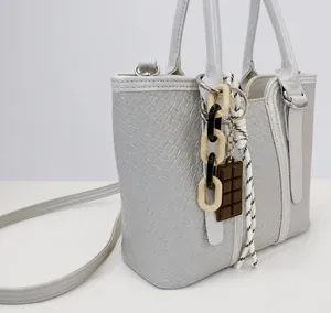 Détail de sac à main texturé avec chaîne décorative et pendentifs tendance amovibles