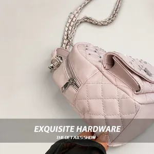 Dettaglio ravvicinato della borsa in pelle trapuntata rosa con borchie argentate