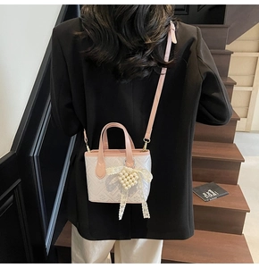 Detail of pink and white jacquard mini bucket bag with lace bow and pearl heart charm