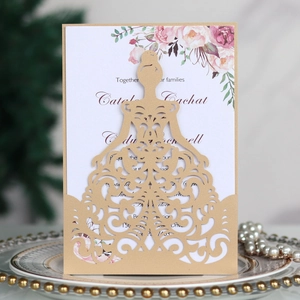 Detail of laser-cut gold wedding invitation with baroque pattern and floral inner card