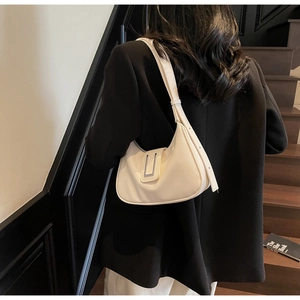 Close-up of a cream lychee leather underarm bag with a sleek silver rectangular buckle