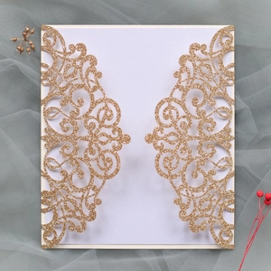 Detail of laser-cut gold glitter wedding invitation with European floral patterns