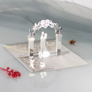 Detail of laser-cut 3D wedding invitation with silver mirror finish and couple silhouette