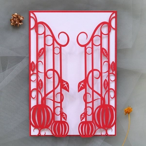 Close-up of laser-cut red cardstock showing intricate pumpkin and scrollwork patterns