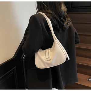 Detail of off-white dumpling bag with pebble grain leather and silver metal buckle