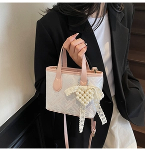 Detail of floral jacquard tote with pink leather trim and pearl heart charm