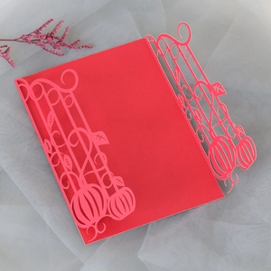 Detail showing the intricate laser-cut pumpkin and vine patterns on a festive red invitation