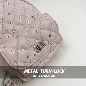 Dettaglio della borsa trapuntata rosa con chiusura a scatto argentata e decoro in strass