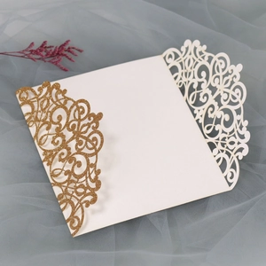 Detail of laser-cut ivory invitation card with gold glitter vine patterns on tulle