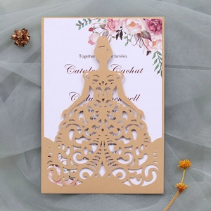 Close-up of laser-cut wedding invitation with elegant floral cards and lace background