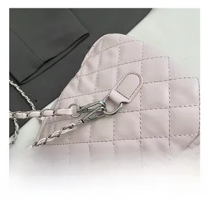 Dettaglio del gancio in metallo argento e della tracolla a catena in pelle rosa della borsa