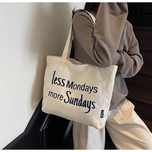 Detail of canvas tote bag with 'less Mondays more Sundays' slogan and side label