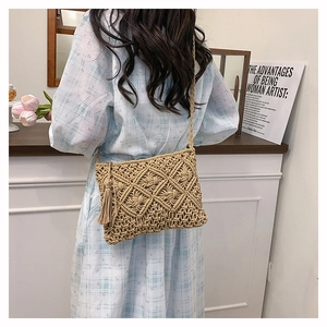 Détail du sac à bandoulière tissé bohème avec motifs en losange et pompons longs