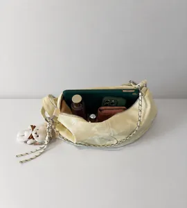 Large capacity creamy white shoulder bag interior view with silver chain and bear charm