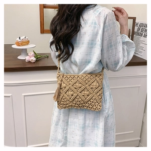 Detail of bohemian woven crossbody bag with diamond pattern and side tassels