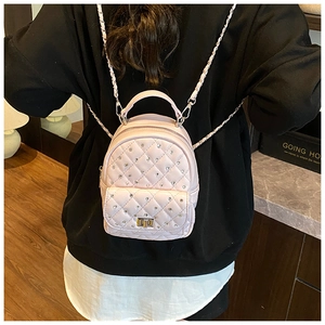 Detailed back view of a pink quilted mini backpack with crystal accents and chain straps