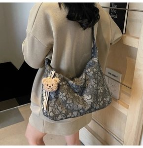 Schultertasche aus Canvas mit Blumenmuster, Halbmondform und Plüschbär-Anhänger