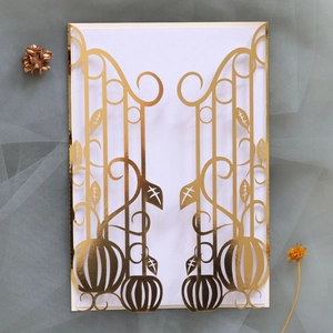 Detail of laser-cut golden invitation with pumpkin design and intricate gate patterns