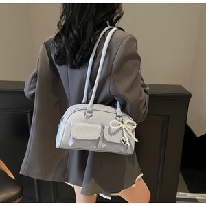 Detail of light blue lychee pattern shoulder bag with decorative pearl bow pendant